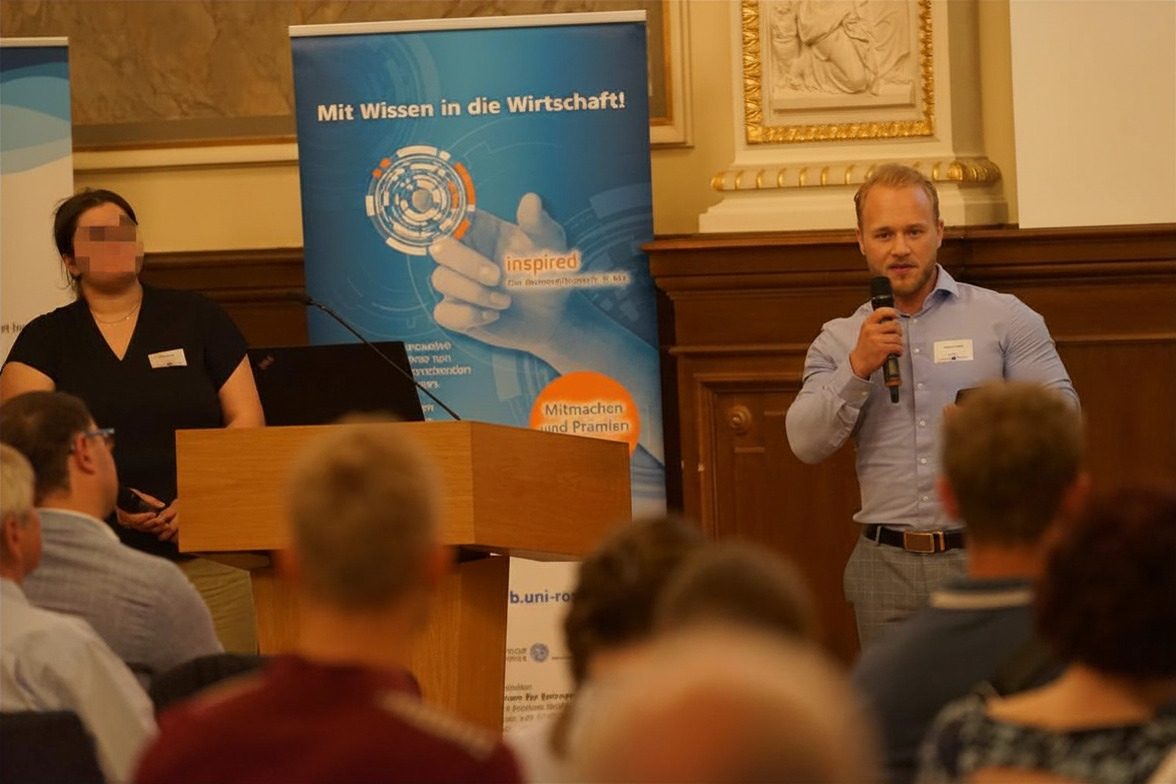 Hannes Franck präsentiert die App EduAgent am Mikrofon beim Ideenwettbewerb 2025
